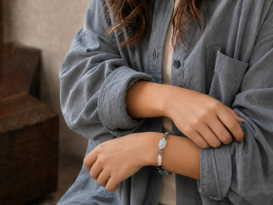 bracelets-01-featured.webp A woman in a slate-blue overshirt styling a crystal bracelet with an everyday outfit.