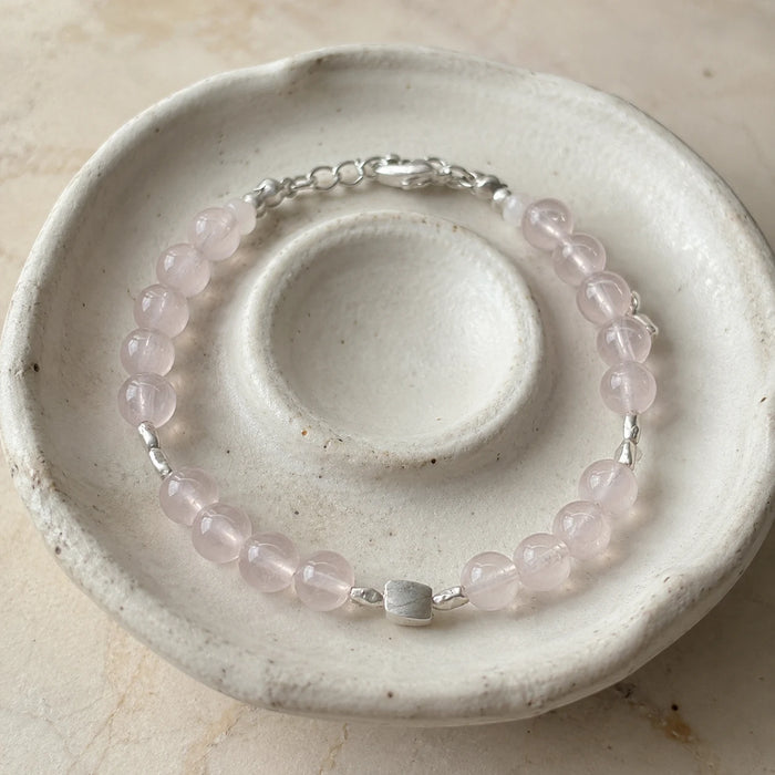 First Blush Poise Bracelet styled on a ceramic dish with rose quartz, white quartz, and silver accents