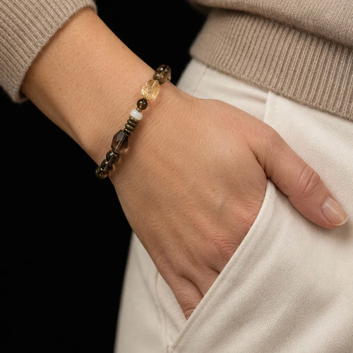 Strata Afterglow Bracelet worn on the wrist, showing its layered smoky quartz, wood, and warm mineral tones