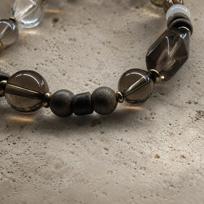 Close-up of the Strata Afterglow Bracelet with smoky quartz, dark moonstone, sandalwood, and brass spacers