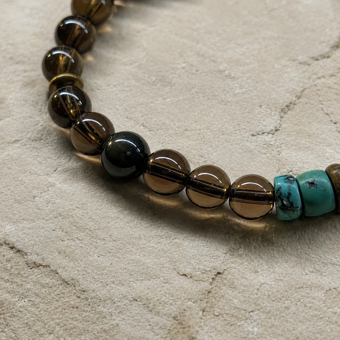 Close-up of the Strata Dusk Passage Bracelet with smoky quartz, sandalwood, brass spacers, turquoise, and chalcedony details