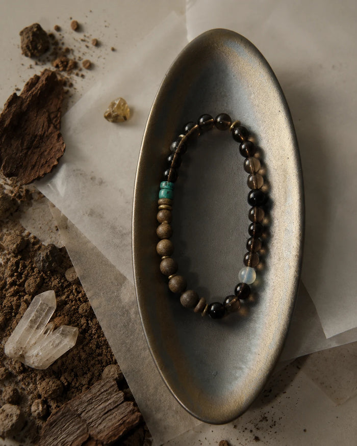 Strata Dusk Passage Bracelet styled with warm brown stones, sandalwood, turquoise, and brass accents