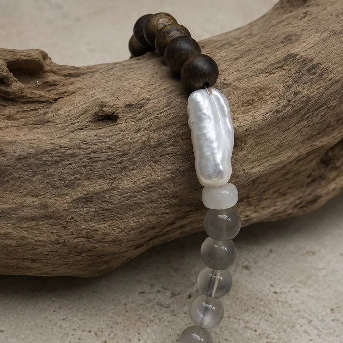 Close-up of the Strata Pale Drift Bracelet with freshwater pearl, white moonstone, black moonstone, smoky quartz, and agarwood