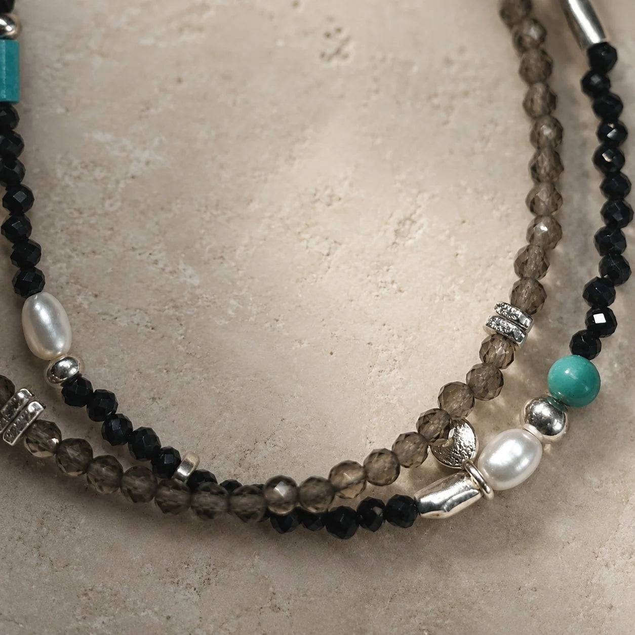 Close-up of the Strata Still Current Bracelet with black spinel, smoky quartz, turquoise, pearl, and 925 sterling silver