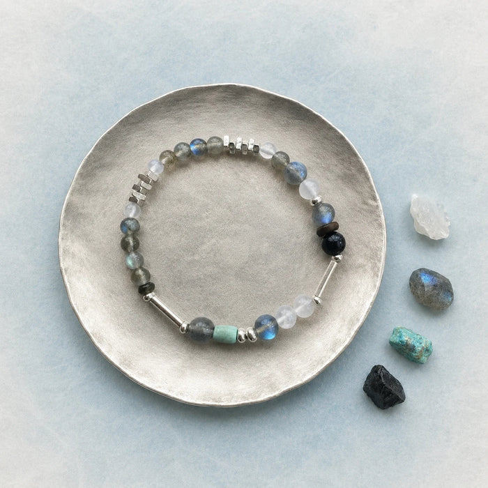 Veiled Light Blue Hour Bracelet styled on a pale blue surface with blue-grey moonstone and contrasting natural accents