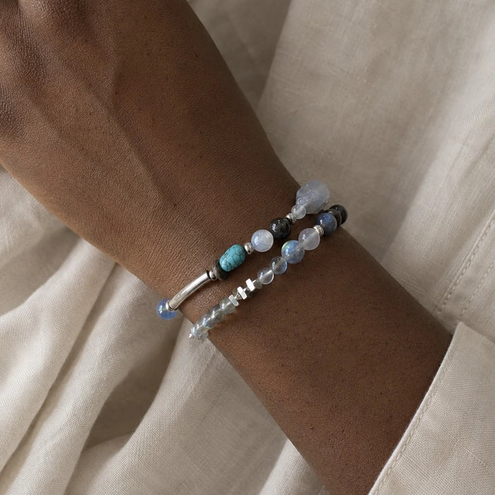 Veiled Light Blue Hour Bracelet layered on the wrist with silver and gemstone bracelets for an everyday styling look