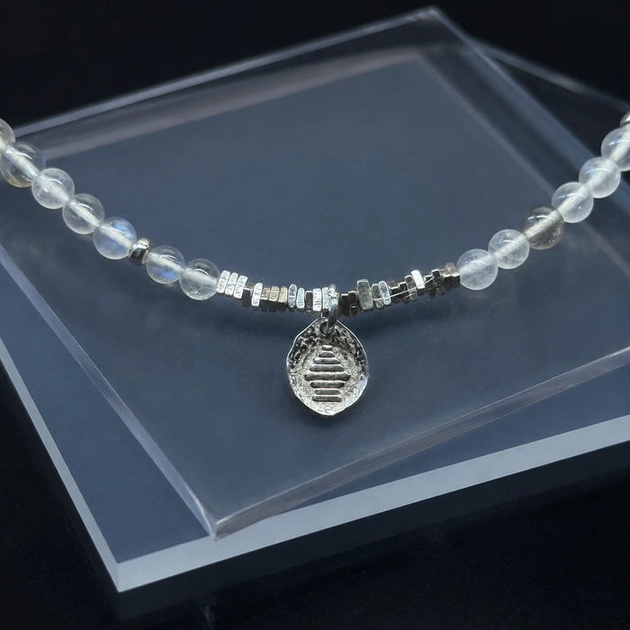 Detail of the Veiled Light Echo Bracelet with 925 sterling silver charm and fine moonstone beadwork