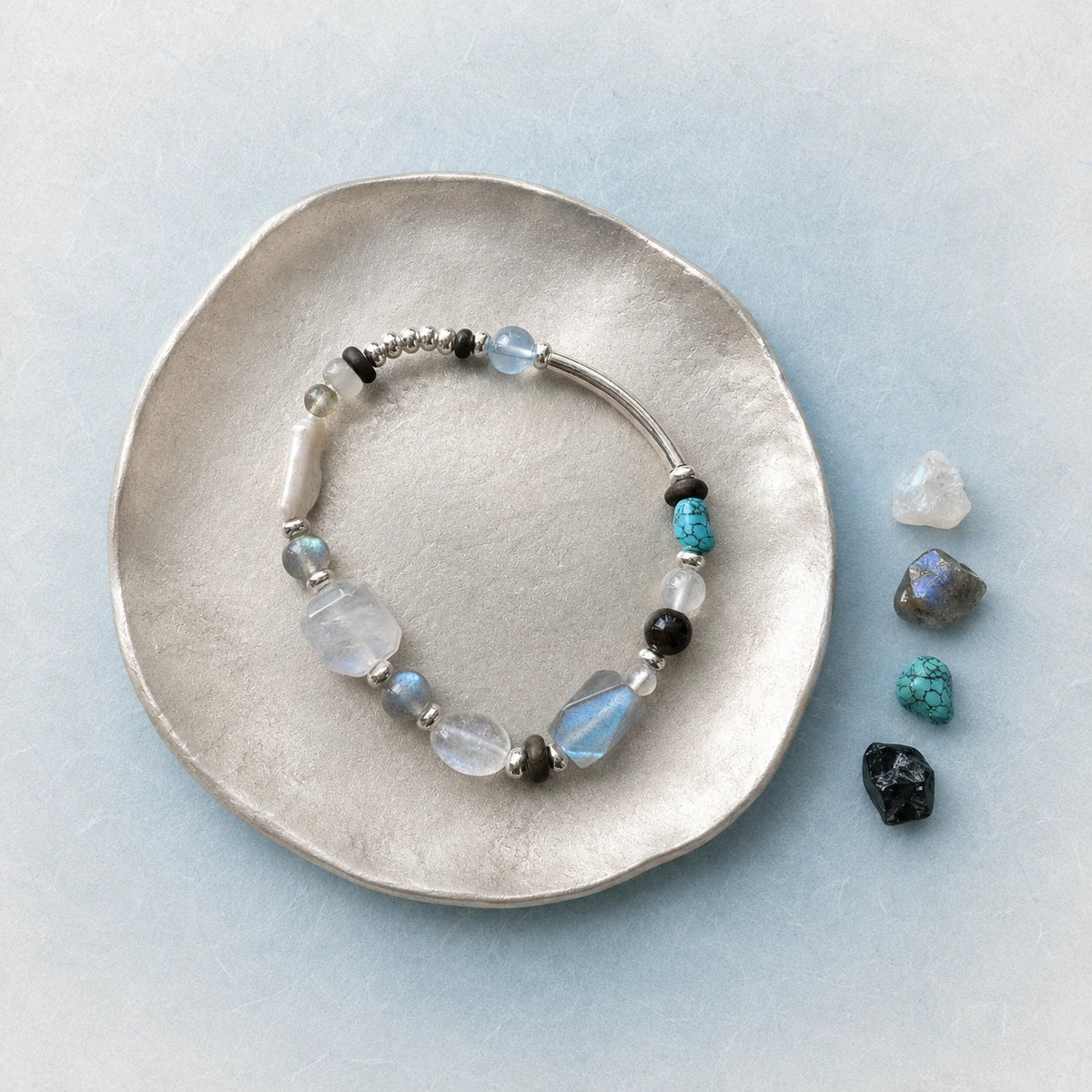 Veiled Light Prism Bracelet styled on a silver dish with moonstone, labradorite, aquamarine, and turquoise accents