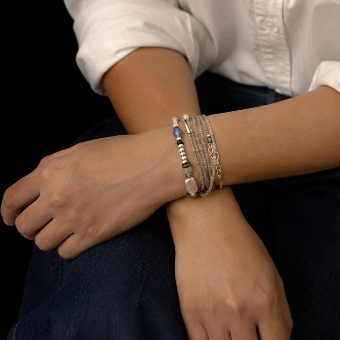 Veiled Light Prism Bracelet layered with other silver and gemstone bracelets on the wrist