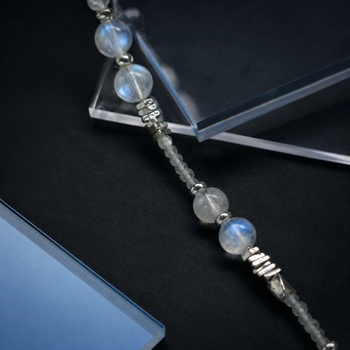 Veiled Light Trace Bracelet styled on a dark surface with moonstone and sterling silver details